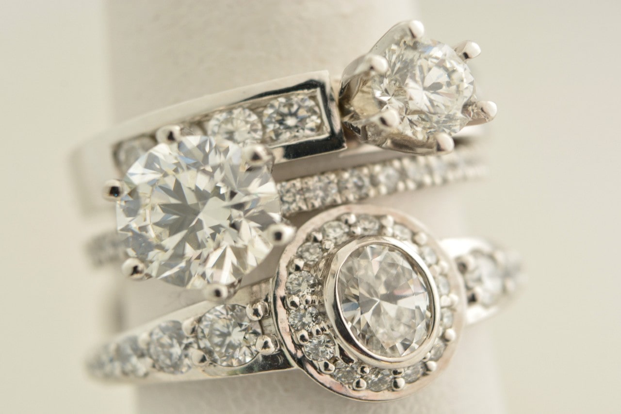 A stunning selection of diamond engagement rings on a cream-colored backdrop.