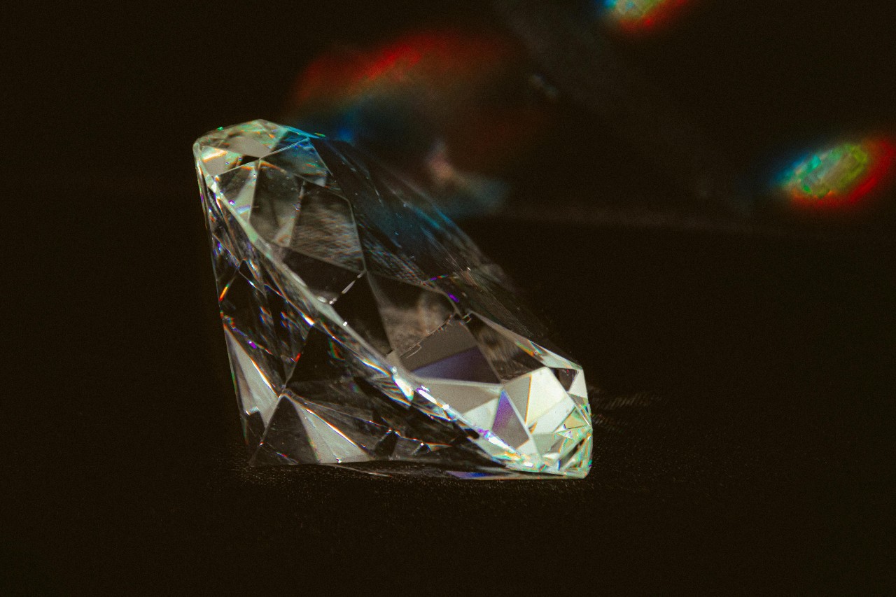 A close-up of a round-cut diamond on a dark background.