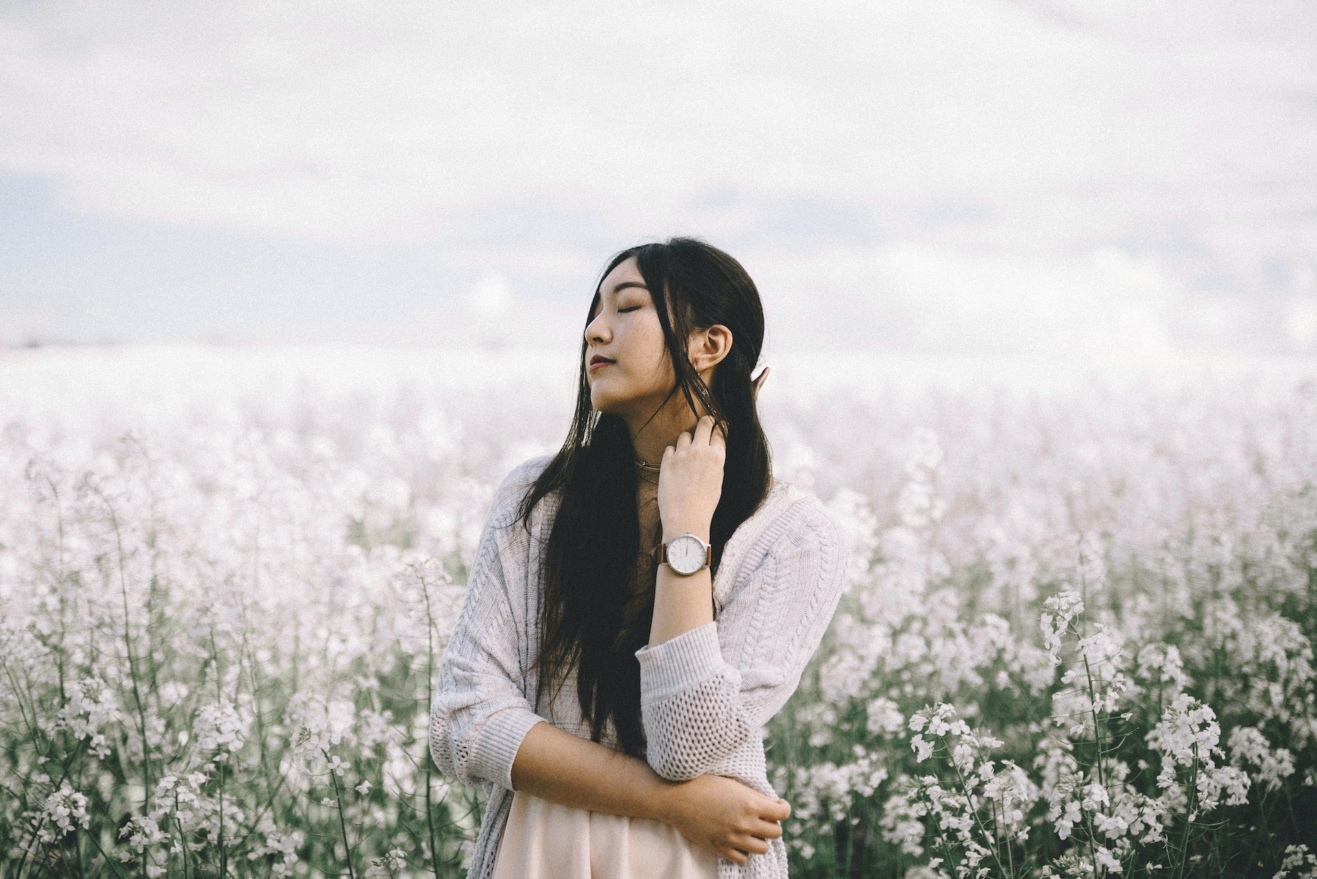 lady standing in a field of flowers wearing a wristwatch